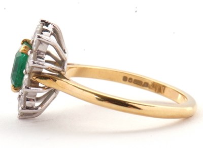 Lot 74 - An 18ct emerald and diamond ring, the central...