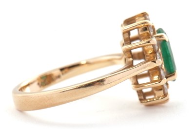 Lot 25 - An emerald and diamond cluster ring, set with...