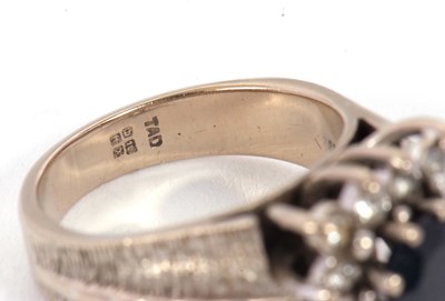 Lot 14 - An 18ct sapphire and diamond ring, the central...