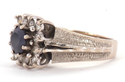 Lot 14 - An 18ct sapphire and diamond ring, the central...