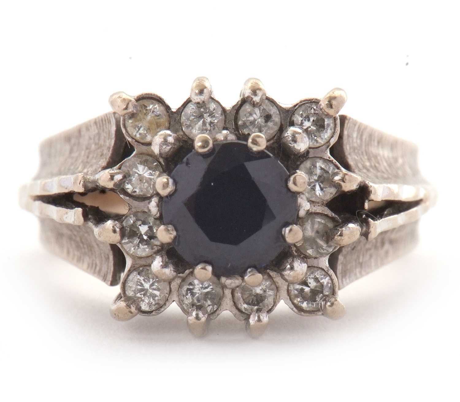Lot 14 - An 18ct sapphire and diamond ring, the central...