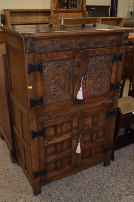 Lot 303 - A heavily carved reproduction oak cabinet...