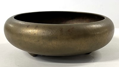 Lot 234 - An Oriental brass bowl raised on three stub...