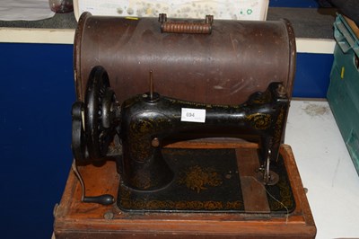 Lot 694 - A cased Singer sewing machine - hand turned