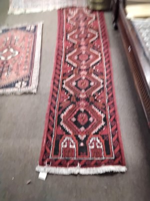 Lot 581 - A small Afghan runner carpet decorated with...