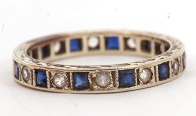 Lot 43 - A sapphire and white stone eternity ring, set...