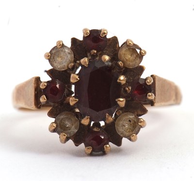 Lot 62 - A 9ct garnet ring, with oval and round garnets...