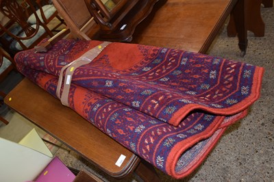 Lot 361 - A machine made red floor rug