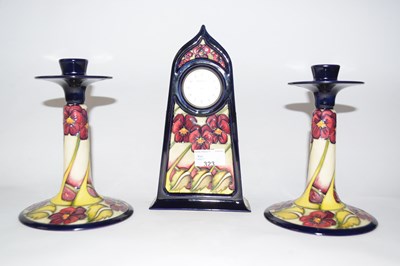 Lot 323 - A pair of Moorcroft pansy pattern candlesticks...